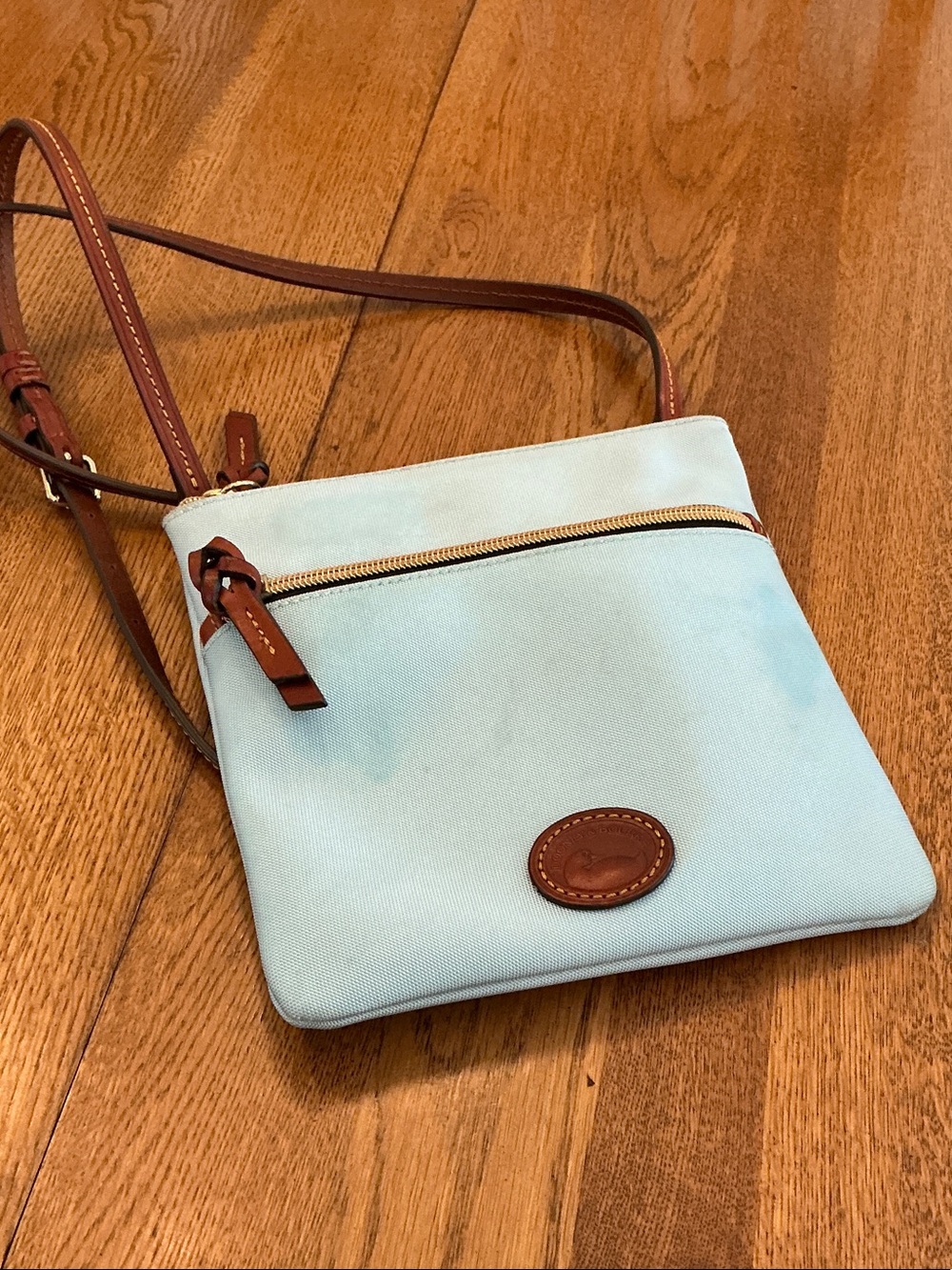 Woman’s Dooney & Bourke light blue cross body bag. 8”x8”. Leather strap. Cute!